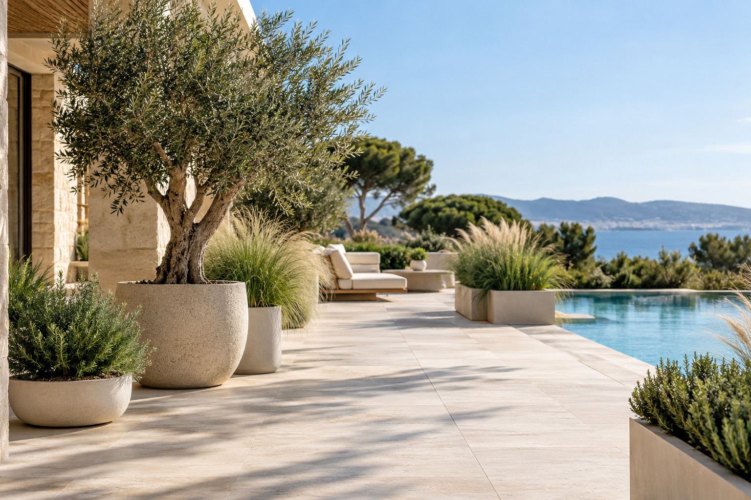 Terrasse de piscine aménagée avec plusieurs formats de plantes artificielles sans gêner la circulation.